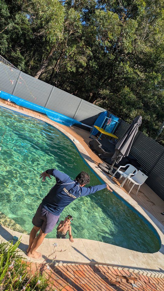 Coach demonstrating a dive from the pool edge