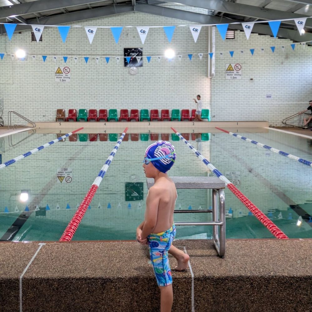 Young swimmer on the blocks at an indoor pool